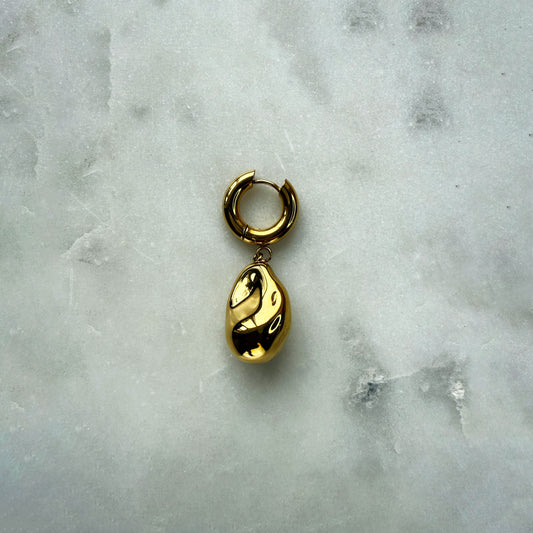 A Single Earring With A Gold Pearl Pendant