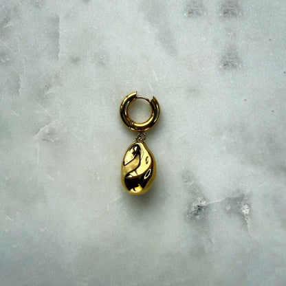 A Single Earring With A Gold Pearl Pendant