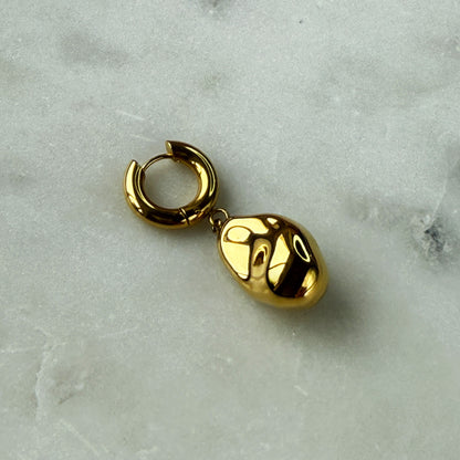 A Single Earring With A Gold Pearl Pendant